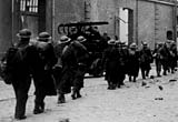 Troops file into Dunkirk, under bombardment