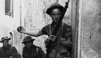 A soldier throws a hand grenade while attempting to clear an Italian town of remaining German forces