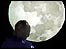 Boy silhouetted against the moon