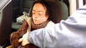 Liz is helped with her seatbelt