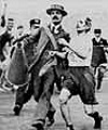 Marathon runner Dorando Pietri helped to the line