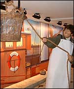 A life-size model hoists a basket.