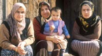 Women in Muslim hedscarfs holding a child